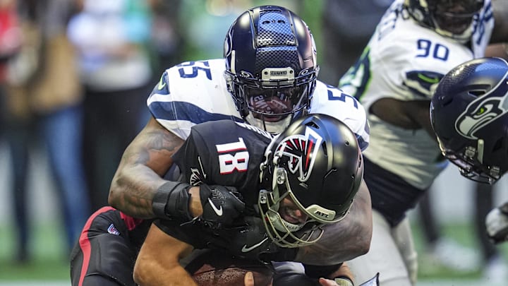 Oct 20, 2024; Atlanta, Georgia, USA; Atlanta Falcons quarterback Kirk Cousins (18) is sacked by Seattle Seahawks defensive end Dre'Mont Jones (55) at Mercedes-Benz Stadium. Mandatory Credit: Dale Zanine-Imagn Images
