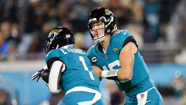 Dec 17, 2023; Jacksonville, Florida, USA;  Jacksonville Jaguars quarterback Trevor Lawrence (16) hands off to running back Travis Etienne Jr. (1) against the Baltimore Ravens in the first quarter at EverBank Stadium. Mandatory Credit: Nathan Ray Seebeck-Imagn Images