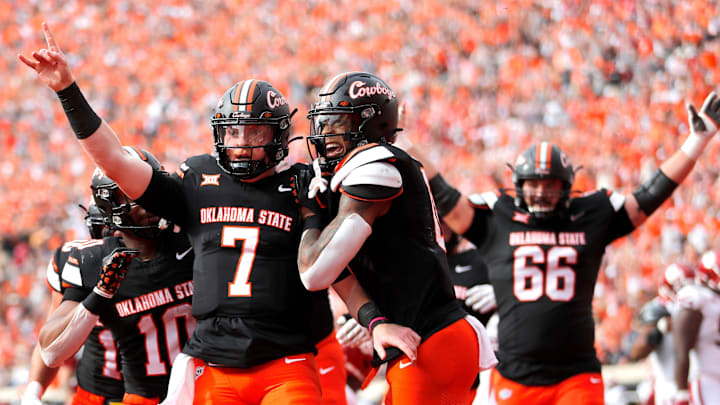 Oklahoma State's Alan Bowman (7) celebrates his touchdown with Ollie Gordon II (0) in the first half