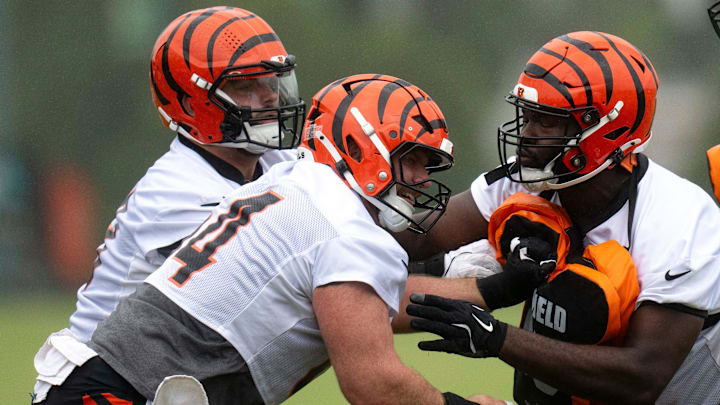 Cincinnati Bengals center Ted Karras (64) and Cincinnati Bengals guard Dylan Fairchild (63) practice blocking Cincinnati Bengals offensive tackle Jalen Rivers (74) during the Cincinnati Bengals practice in Cincinnati on Tuesday, May 27, 2025.