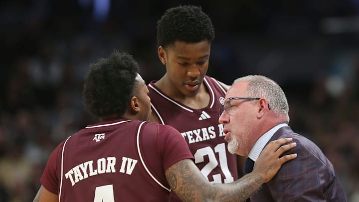 Texas A&M Aggies guard Wade Taylor IV (4) and Texas A&M Aggies forward Pharrel Payne (21) talk to Texas A&M Aggies head coach Buzz Williams Saturday, Dec. 14, 2024, during the NCAA men’s basketball game against the Purdue Boilermakers at Gainbridge Fieldhouse in Indianapolis.