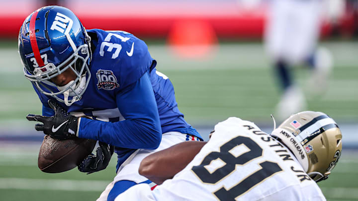 Dec 8, 2024; East Rutherford, New Jersey, USA; New York Giants cornerback Tre Hawkins III (37) intercepts a pass intended for New Orleans Saints wide receiver Kevin Austin Jr. (81) during the second half at MetLife Stadium. 
