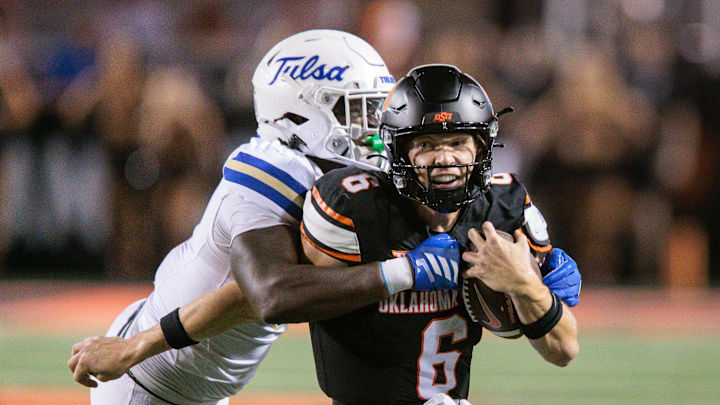 Sep 19, 2025; Stillwater, Oklahoma, USA; Oklahoma State Cowboys quarterback Zane Flores (6) is tackled by Tulsa Golden Hurricane safety Lento Smith Jr. (21) during the second half at Boone Pickens Stadium. Mandatory Credit: William Purnell-Imagn Images