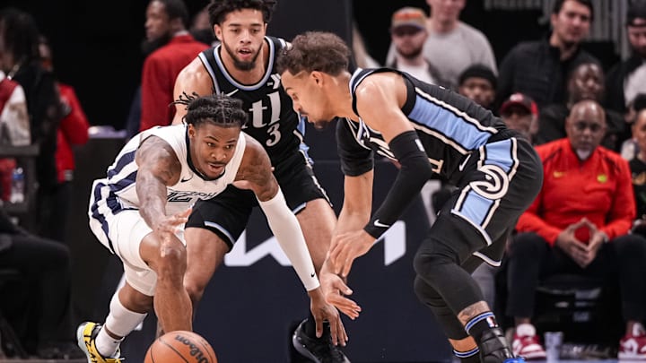 Dec 23, 2023; Atlanta, Georgia, USA; Memphis Grizzlies guard Ja Morant (12) loses the ball defended by Atlanta Hawks guards Seth Lundy (3) and Trae Young (11) during the first half at State Farm Arena. Mandatory Credit: Dale Zanine-Imagn Images
