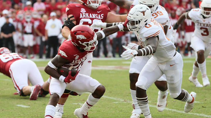 Sep 11, 2021; Fayetteville, Arkansas, USA; Texas Longhorns linebacker DeMarvion Overshow (0) tackles Arkansas Razorbacks running back Trelon Smith (22) during the first quarter at Donald W. Reynolds Razorback Stadium. Mandatory Credit: Nelson Chenault-Imagn Images Sep 11, 2021; Fayetteville, Arkansas, USA; Texas Longhorns linebacker DeMarvion Overshow (0) tackles Arkansas Razorbacks running back Trelon Smith (22) during the first quarter at Donald W. Reynolds Razorback Stadium. Mandatory Credit: Nelson Chenault-Imagn Images