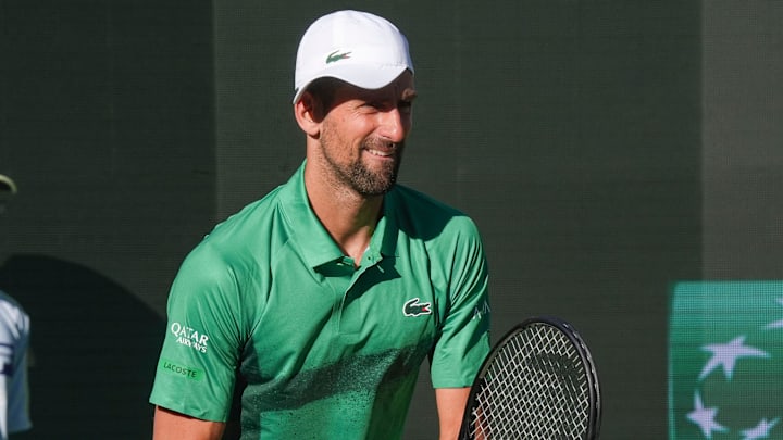 Novak Djokovic appears amused by the crowd’s reaction of his hat turned sideways to help see in the late afternoon sunlight during his match against Botic Van De Zandschulp during Round 2 of the BNP Paribas Open in Indian Wells, Calif., March 8, 2025.