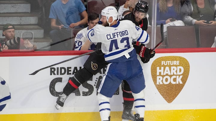 Sep 24, 2023; Ottawa, Ontario, CAN; Toronto Maple Leafs left wing Kyle Clifford (43) checks Ottawa Senators center Mark Kastelic (12) in the third period at the Canadian Tire Centre. Mandatory Credit: Marc DesRosiers-Imagn Images