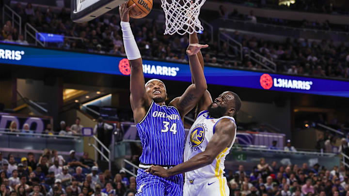 Nov 18, 2025; Orlando, Florida, USA; Orlando Magic center Wendell Carter Jr. (34) goes to the basket against Golden State Warriors forward Draymond Green (23) during the first quarter at Kia Center. Mandatory Credit: Mike Watters-Imagn Images