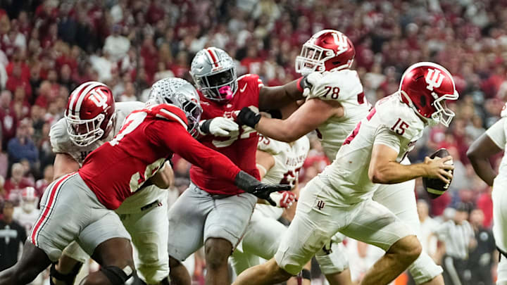 Indiana Hoosiers quarterback Fernando Mendoza (15) scrambles away from Ohio State Buckeyes defensive end Kenyatta Jackson Jr. (97) during the Big Ten Conference championship game at Lucas Oil Stadium in Indianapolis on Dec. 6, 2025. Ohio State lost 13-10. Indiana Hoosiers quarterback Fernando Mendoza (15) scrambles away from Ohio State Buckeyes defensive end Kenyatta Jackson Jr. (97) during the Big Ten Conference championship game at Lucas Oil Stadium in Indianapolis on Dec. 6, 2025. Ohio State lost 13-10.