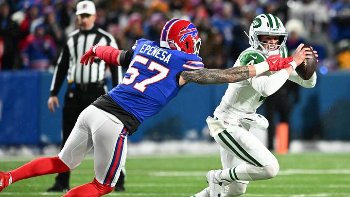 Jan 4, 2026; Orchard Park, New York, USA; New York Jets quarterback Brady Cook (4) scrambles with the ball under pressure from Buffalo Bills defensive end AJ Epenesa (57) during the first half at Highmark Stadium. Mandatory Credit: Mark Konezny-Imagn Images