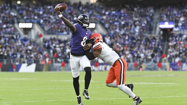 Nov 12, 2023; Baltimore, Maryland, USA;  Baltimore Ravens quarterback Lamar Jackson (8) throws on the run as Cleveland Browns defensive end Myles Garrett (95) hits at M&T Bank Stadium. Mandatory Credit: Tommy Gilligan-Imagn Images