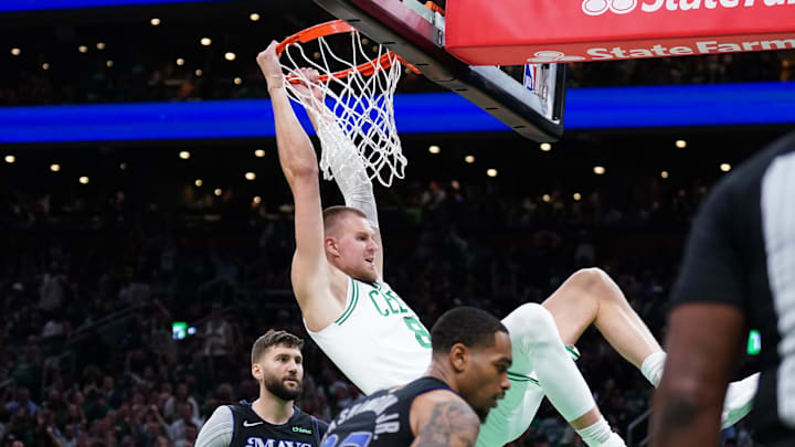 Jun 6, 2024; Boston, Massachusetts, USA; Boston Celtics center Kristaps Porzingis (8) dunks against Dallas Mavericks forward P.J. Washington (25) and forward Maxi Kleber (42) in the third quarter during game one of the 2024 NBA Finals at TD Garden. Mandatory Credit: David Butler II-USA TODAY Sports