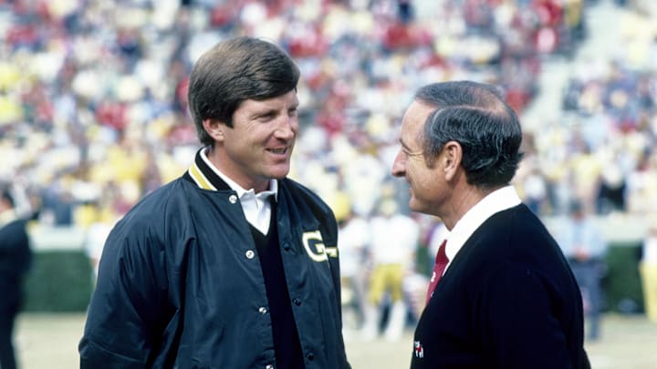 Nov 27, 1982; Athens, GA, USA; FILE PHOTO; Georgia Tech Yellow Jackets head coach Bill Curry (left) talks with Georgia Bulldogs head coach Vince Dooley (right) before the game at Sanford Stadium. Mandatory Credit: Manny Rubio-Imagn Images.