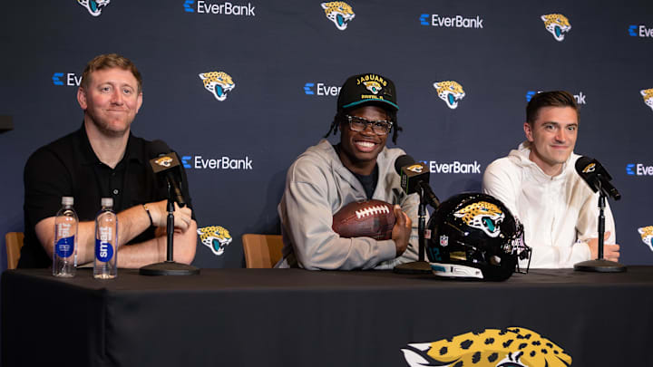 Apr 25, 2025; Jacksonville, FL, USA; Jacksonville Jaguars head coach Liam Coen  and first round draft pick Travis Hunter talk to the media during a press conference at Miller Electric Center. Mandatory Credit: Travis Register-Imagn Images