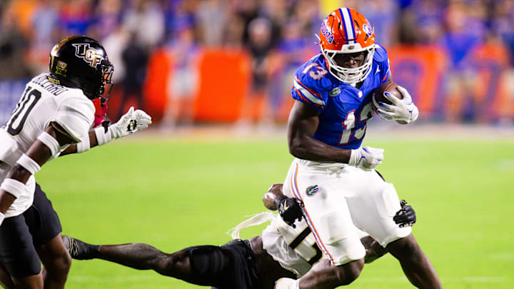 Florida Gators running back Jadan Baugh (13) breaks a tackle attempt by UCF Knights defensive back Ladarius Tennison (13) during the first half at Ben Hill Griffin Stadium in Gainesville, FL on Saturday, October 5, 2024. [Doug Engle/Gainesville Sun]