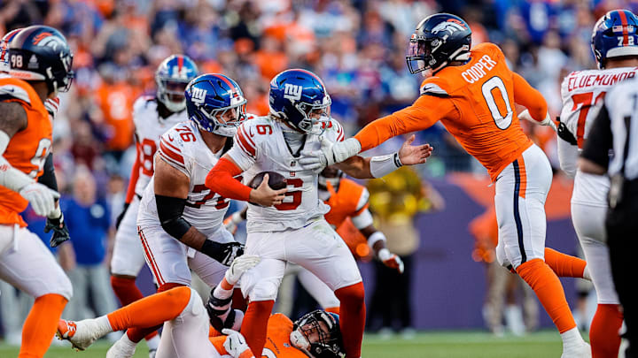 Oct 19, 2025; Denver, Colorado, USA; New York Giants quarterback Jaxson Dart (6) is sacked by Denver Broncos defensive end Zach Allen (99) and linebacker Jonathon Cooper (0) as guard Jon Runyan Jr. (76) defends in the fourth quarter at Empower Field at Mile High.  