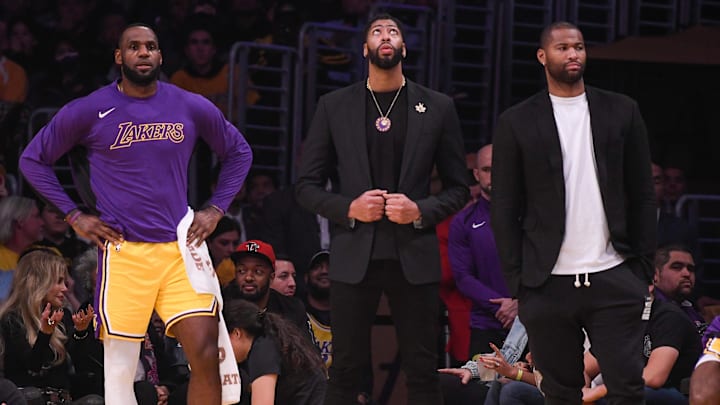 Jan 13, 2020; Los Angeles, California, USA;  Los Angeles Lakers forward LeBron James (left), Anthony Davis (center) and Los Angeles Lakers center DeMarcus Cousins (right) watch the action during the second quarter against the Cleveland Cavaliers at Staples Center. Mandatory Credit: Robert Hanashiro-Imagn Images