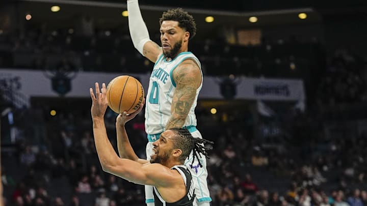 Jan 29, 2025; Charlotte, North Carolina, USA; Brooklyn Nets forward Tosan Evbuomwan (12) is fouled on his way to the rim by Charlotte Hornets forward Miles Bridges (0) during the second quarter at Spectrum Center. Mandatory Credit: Jim Dedmon-Imagn Images