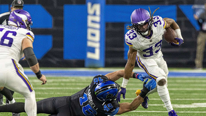 Jan 5, 2025; Detroit, Michigan, USA; Minnesota Vikings running back Aaron Jones (33) avoids a tackle from Detroit Lions linebacker Jack Campbell (46) during the second half at Ford Field. Mandatory Credit: David Reginek-Imagn Images