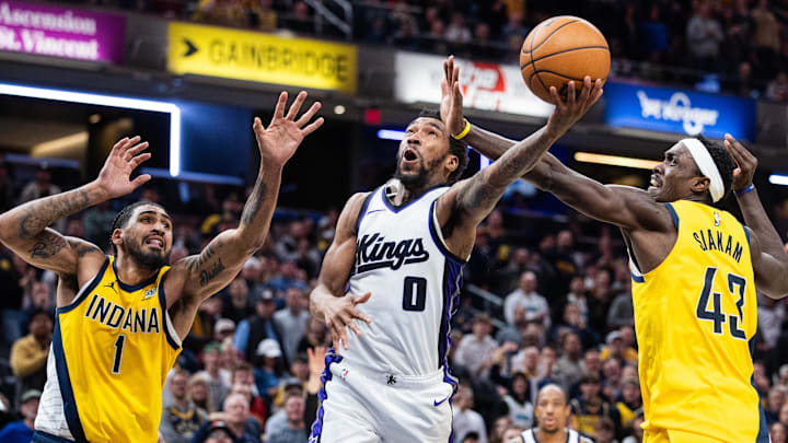 Mar 31, 2025; Indianapolis, Indiana, USA; Sacramento Kings guard Malik Monk (0) shoots the ball while Indiana Pacers forward Obi Toppin (1) and forward Pascal Siakam (43)  defend in the second half at Gainbridge Fieldhouse. 