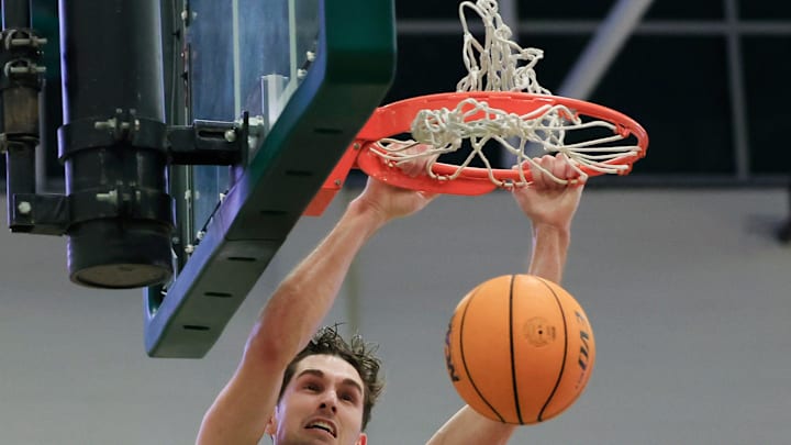 North Florida Ospreys guard Nate Lliteras (2) dunks on Jacksonville Dolphins forward Zimi Nwokeji (16) late in game during the second half of an NCAA men’s basketball matchup Saturday, Feb. 1, 2025 at Jacksonville University in Jacksonville, Fla. UNF held off a late rally from JU defeating them 81-78. [Corey Perrine/Florida Times-Union]