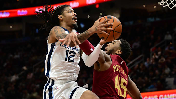 Feb 23, 2025; Cleveland, Ohio, USA; Memphis Grizzlies guard Ja Morant (12) is fouled by Cleveland Cavaliers guard Donovan Mitchell (45) during the second half at Rocket Arena. Mandatory Credit: Ken Blaze-Imagn Images