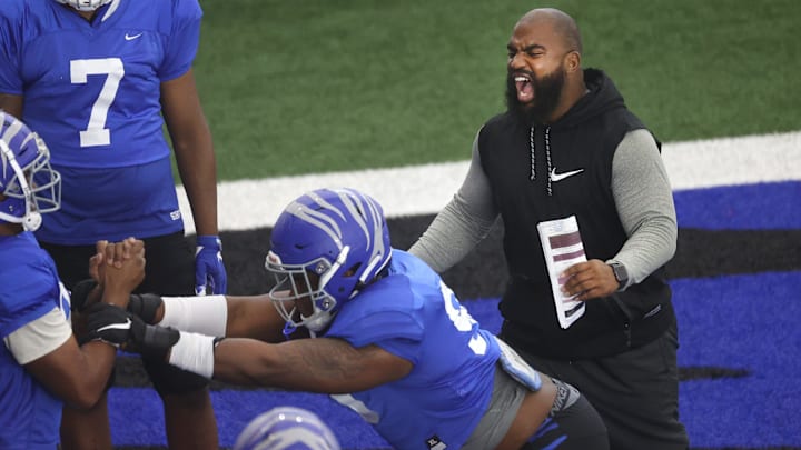 Memphis Tigers Defensive Line Coach Kyle Pope yells out to his players as they hold football
