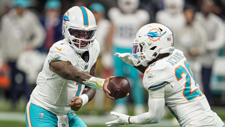 Miami Dolphins quarterback Tua Tagovailoa (1) hands the ball off to running back De'Von Achane (28) against the Atlanta Falcons during the first quarter at Mercedes-Benz Stadium. 
