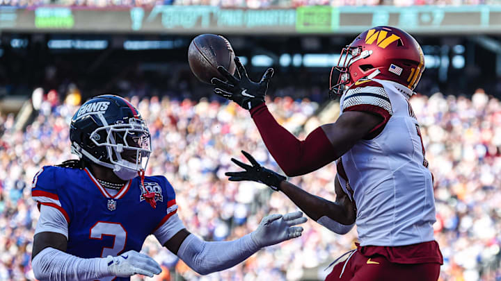 Nov 3, 2024; East Rutherford, New Jersey, USA; Washington Commanders wide receiver Terry McLaurin (17) catches a touchdown pass as New York Giants cornerback Deonte Banks (3) defends during the first half at MetLife Stadium.  