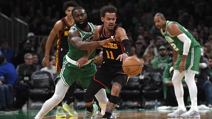 Feb 7, 2024; Boston, Massachusetts, USA;  Boston Celtics guard Jaylen Brown (7) tries to steal the ball from Atlanta Hawks guard Trae Young (11) during the second half at TD Garden. Mandatory Credit: Bob DeChiara-Imagn Images