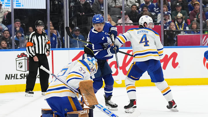 Dec 15, 2024; Toronto, Ontario, CAN; Toronto Maple Leafs right wing William Nylander (88) battles for a puck in front of the net with Buffalo Sabres defenseman Bowen Byram (4) during the third period at Scotiabank Arena. Mandatory Credit: Nick Turchiaro-Imagn Images