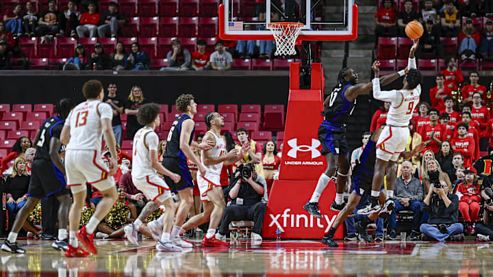 Huskies center Franck Kepnang (11) blocks a Maryland shot by forward Solomon Washington (9).