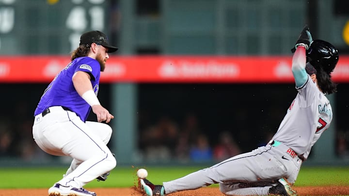 Sep 16, 2024; Denver, Colorado, USA; Colorado Rockies second base Brendan Rodgers (7) prepares to field the ball as Arizona Diamondbacks outfielder Corbin Carroll (7) attempts to steal second in the third inning at Coors Field. Mandatory Credit: Ron Chenoy-Imagn Images