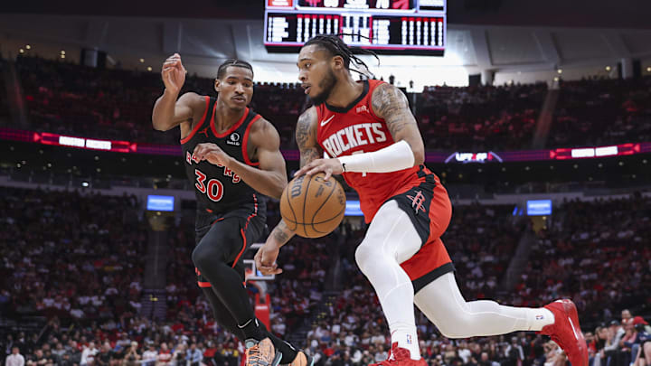 Feb 9, 2025; Houston, Texas, USA; Houston Rockets forward Cam Whitmore (7) drives with the ball as Toronto Raptors guard Ochai Agbaji (30) defends during the fourth quarter at Toyota Center. Mandatory Credit: Troy Taormina-Imagn Images