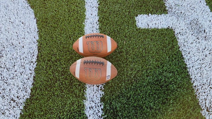 Two footballs sit on an Ohio high school football field