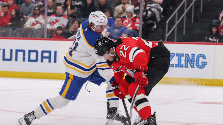 Feb 25, 2026; Newark, New Jersey, USA; Buffalo Sabres right wing Josh Doan (91) shoots the puck as New Jersey Devils defenseman Brett Pesce (22) defends during the third period at Prudential Center. Mandatory Credit: Ed Mulholland-Imagn Images