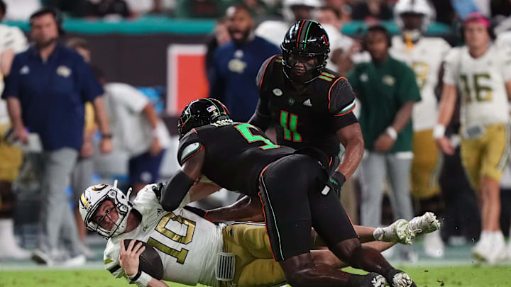 Oct 7, 2023; Miami Gardens, Florida, USA; Miami Hurricanes safety Kamren Kinchens (5) tackles Georgia Tech Yellow Jackets quarterback Haynes King (10) in the first half at Hard Rock Stadium. Mandatory Credit: Jasen Vinlove-Imagn Images