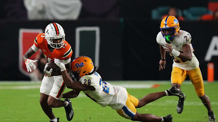 Nov 26, 2022; Miami Gardens, Florida, USA; Pittsburgh Panthers defensive back Noah Biglow (28) attempts to tackle Miami Hurricanes wide receiver Jacolby George (15) during the second half at Hard Rock Stadium. Mandatory Credit: Jasen Vinlove-Imagn Images
