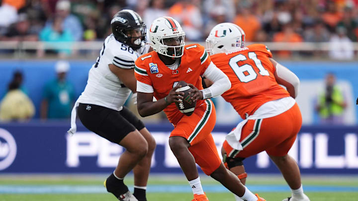Dec 28, 2024; Orlando, FL, USA; Miami Hurricanes quarterback Cam Ward (1) scrambles with the ball against the Iowa State Cyclones during the first half at Camping World Stadium. Mandatory Credit: Jasen Vinlove-Imagn Images