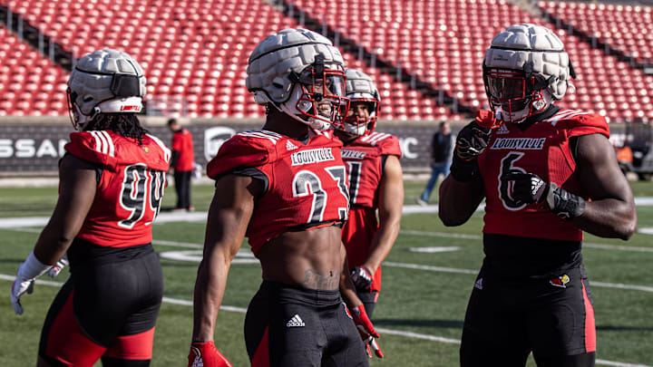 Defensive players get hyped up before team drills during U of L's first spring football practice of
