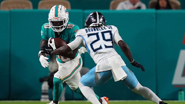 Sep 30, 2024; Miami Gardens, Florida, USA; Miami Dolphins wide receiver Tyreek Hill (10) runs with the ball around Tennessee Titans cornerback Jarvis Brownlee Jr. (29) during the first half at Hard Rock Stadium. Mandatory Credit: Jasen Vinlove-Imagn Images