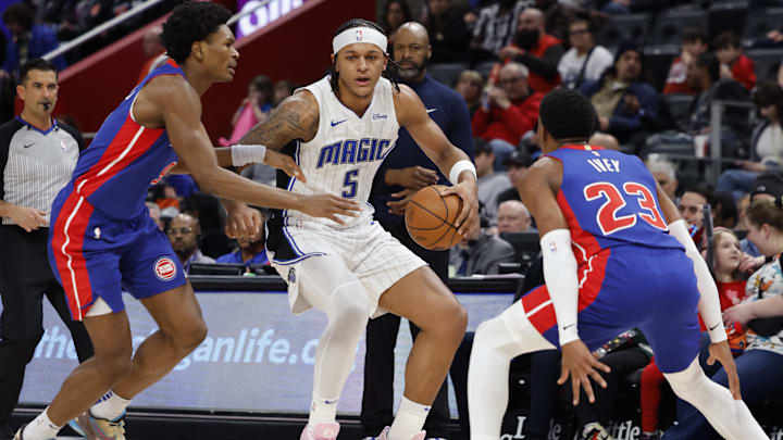 Feb 4, 2024; Detroit, Michigan, USA; Orlando Magic forward Paolo Banchero (5) dribbles defended by Detroit Pistons forward Ausar Thompson (9) and guard Jaden Ivey (23): Rick Osentoski-Imagn Images