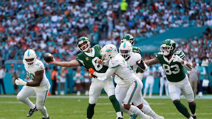 New York Jets quarterback Aaron Rodgers (8) attempts a pass under pressure from Miami Dolphins safety Jordan Poyer (21) during the first half at Hard Rock Stadium. 