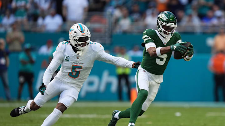 New York Jets wide receiver Garrett Wilson (5) runs with the ball away from Miami Dolphins cornerback Jalen Ramsey (5) during the first half at Hard Rock Stadium.