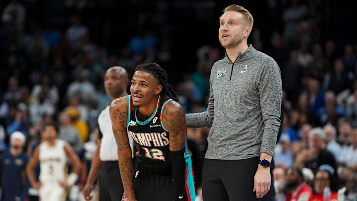Grizzlies' Ja Morant (12) and head coach Tuomas Iisalo watch a teammate take a free throw during the home opener against the New Orleans Pelicans at FedExForum on October 22, 2025. Grizzlies' Ja Morant (12) and head coach Tuomas Iisalo watch a teammate take a free throw during the home opener against the New Orleans Pelicans at FedExForum on October 22, 2025.