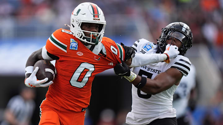 Dec 28, 2024; Orlando, FL, USA; Miami Hurricanes wide receiver Joshisa Trader (0) stiff arms Iowa State Cyclones defensive back Myles Purchase (5) while running for a touchdown during the first half at Camping World Stadium. Mandatory Credit: Jasen Vinlove-Imagn Images