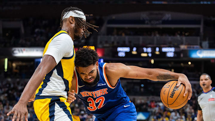 Nov 10, 2024; Indianapolis, Indiana, USA;  New York Knicks center Karl-Anthony Towns (32) dribbles the ball while Indiana Pacers center Myles Turner (33) defends in the second half at Gainbridge Fieldhouse. Mandatory Credit: Trevor Ruszkowski-Imagn Images