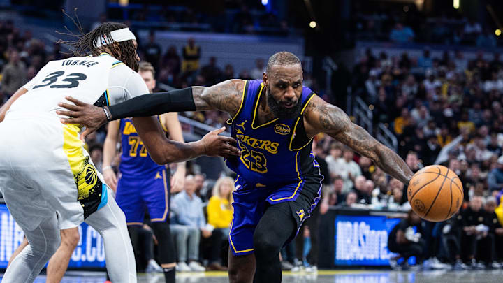 Mar 26, 2025; Indianapolis, Indiana, USA; Los Angeles Lakers forward LeBron James (23) dribbles the ball while  Indiana Pacers center Myles Turner (33) defends in the second half at Gainbridge Fieldhouse. Mandatory Credit: Trevor Ruszkowski-Imagn Images