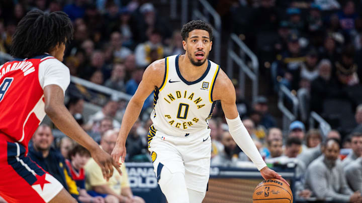 Apr 8, 2025; Indianapolis, Indiana, USA; Indiana Pacers guard Tyrese Haliburton (0) dribbles the ball while Washington Wizards forward Justin Champagnie (9) defends in the first half at Gainbridge Fieldhouse. Mandatory Credit: Trevor Ruszkowski-Imagn Images