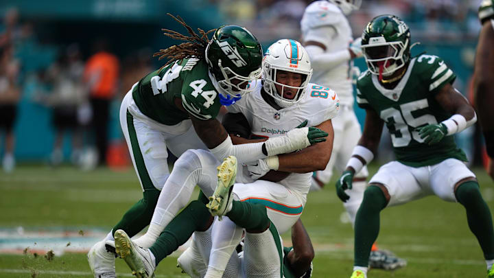 Dec 8, 2024; Miami Gardens, Florida, USA; New York Jets linebacker Jamien Sherwood (44) tackles Miami Dolphins tight end Julian Hill (89) during the first half at Hard Rock Stadium. Mandatory Credit: Jasen Vinlove-Imagn Images